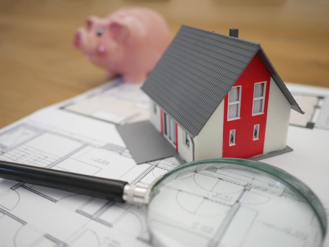 Small house magnifying glass and piggy bank
