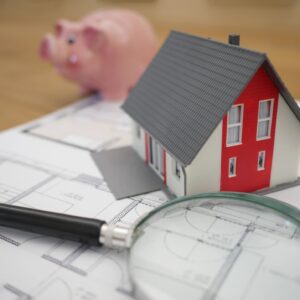 Small house magnifying glass and piggy bank